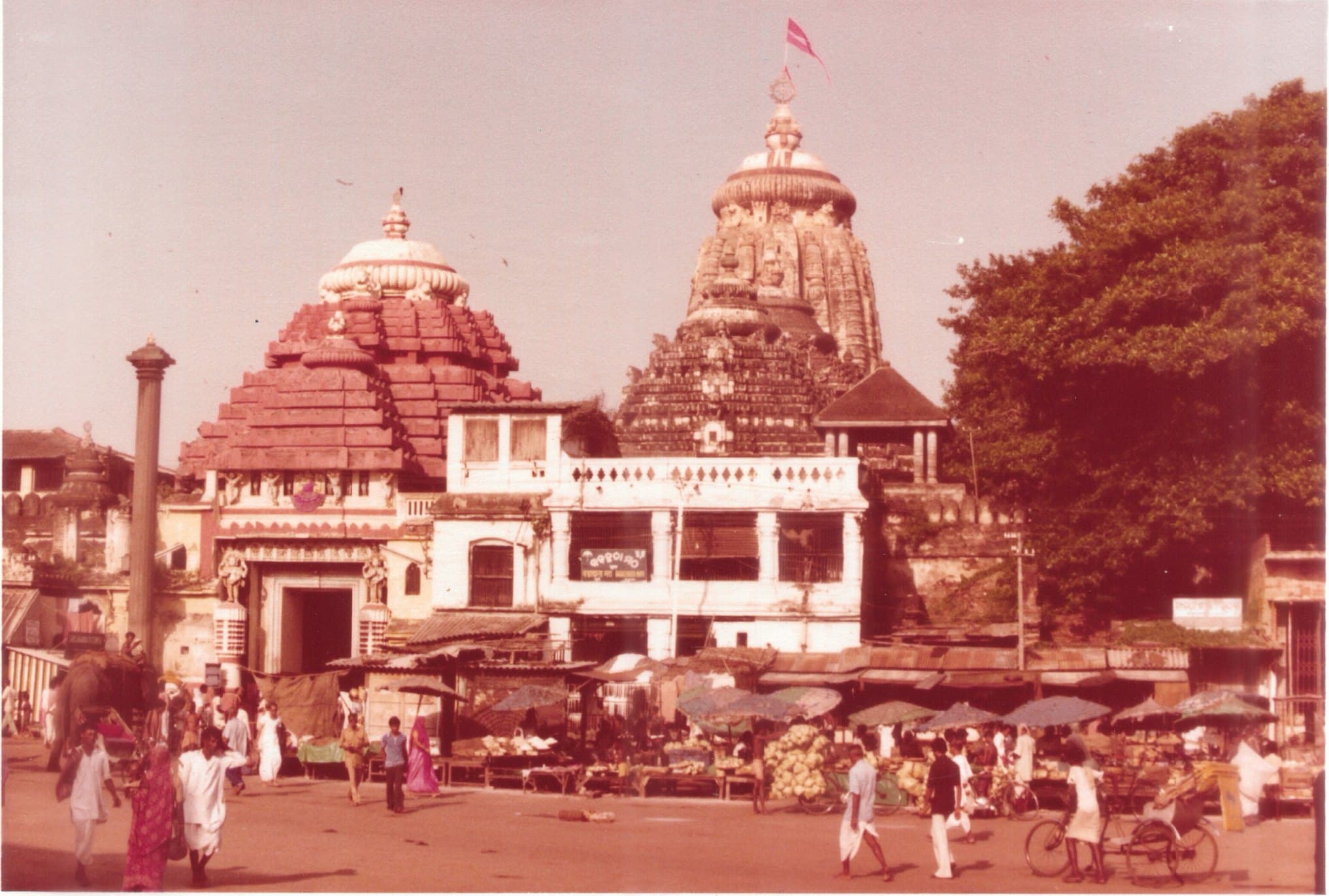 An archive photograph of a temple and the crowded market square in front of it.